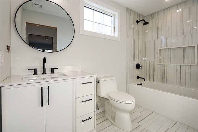 full bathroom with tiled shower / bath, vanity, and toilet