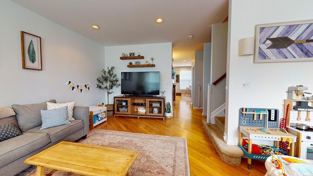 living room with recessed lighting, stairs, and light wood-style flooring