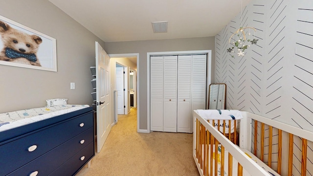 bedroom with visible vents, a closet, and light colored carpet