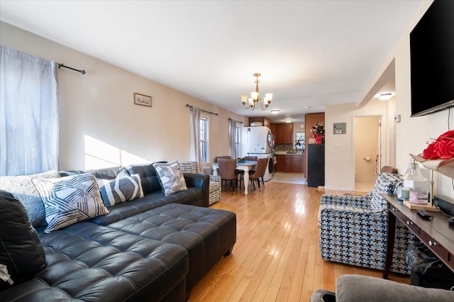 living area featuring light wood finished floors and a notable chandelier