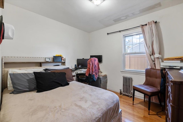 bedroom with radiator and wood finished floors