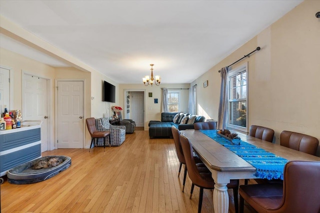 dining space with light wood-style flooring and a chandelier