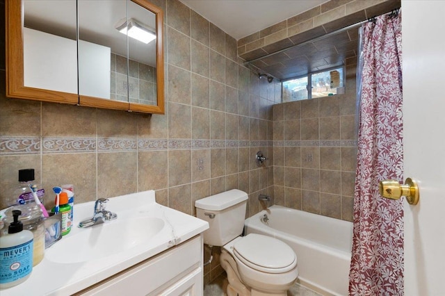 full bath with shower / bath combination with curtain, tile walls, toilet, and vanity