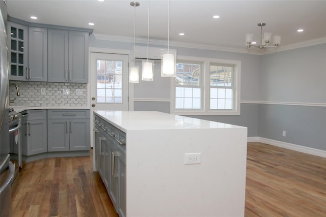 kitchen with pendant lighting, crown molding, and a kitchen island