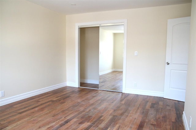 unfurnished bedroom featuring a closet and dark hardwood / wood-style floors