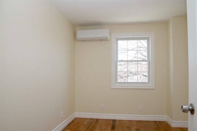 spare room with hardwood / wood-style flooring and an AC wall unit