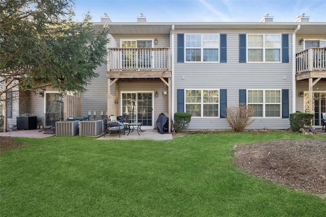 rear view of house featuring central AC unit, a yard, and a patio area