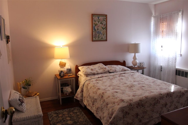 bedroom featuring radiator heating unit and dark wood-type flooring