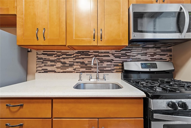 kitchen with stainless steel appliances, sink, and decorative backsplash