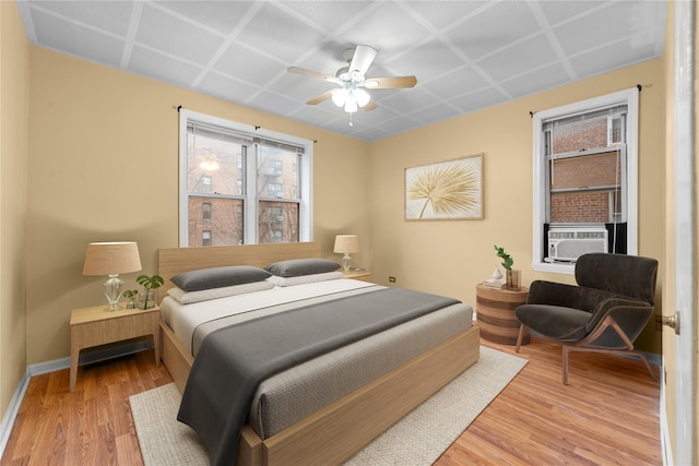 bedroom featuring cooling unit, ceiling fan, and light hardwood / wood-style flooring