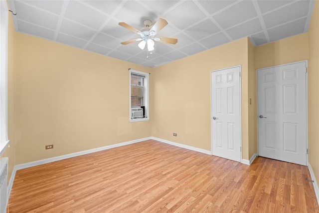 unfurnished room featuring cooling unit, ceiling fan, and light hardwood / wood-style flooring