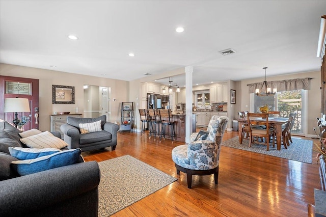 living room featuring light hardwood / wood-style floors and a notable chandelier