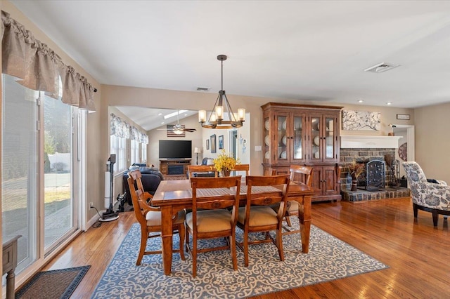 dining area featuring hardwood / wood-style flooring, vaulted ceiling, and a notable chandelier