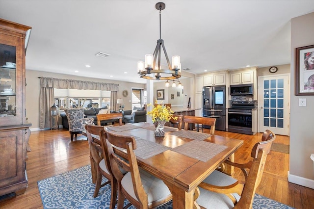 dining area featuring a notable chandelier and light hardwood / wood-style floors