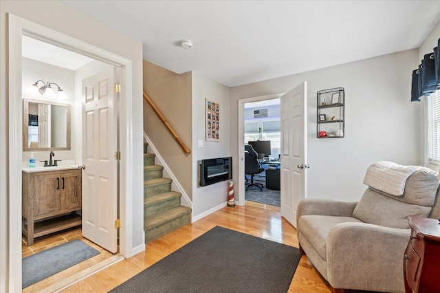 living area featuring sink, heating unit, and light hardwood / wood-style floors