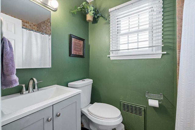 bathroom with vanity, toilet, and radiator