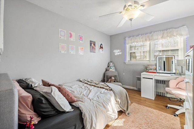 bedroom with radiator, ceiling fan, and light hardwood / wood-style flooring