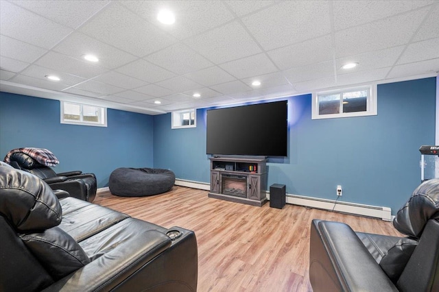 living room featuring light hardwood / wood-style flooring, a baseboard radiator, and a paneled ceiling