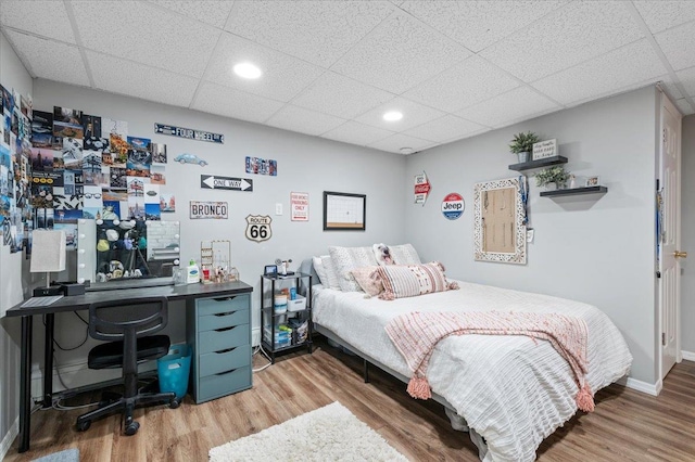 bedroom featuring hardwood / wood-style flooring and a paneled ceiling