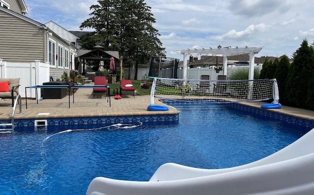 view of swimming pool featuring a trampoline, a pergola, a patio, and a gazebo