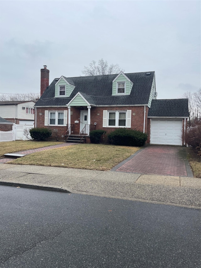 cape cod-style house featuring brick siding, decorative driveway, a front yard, and fence