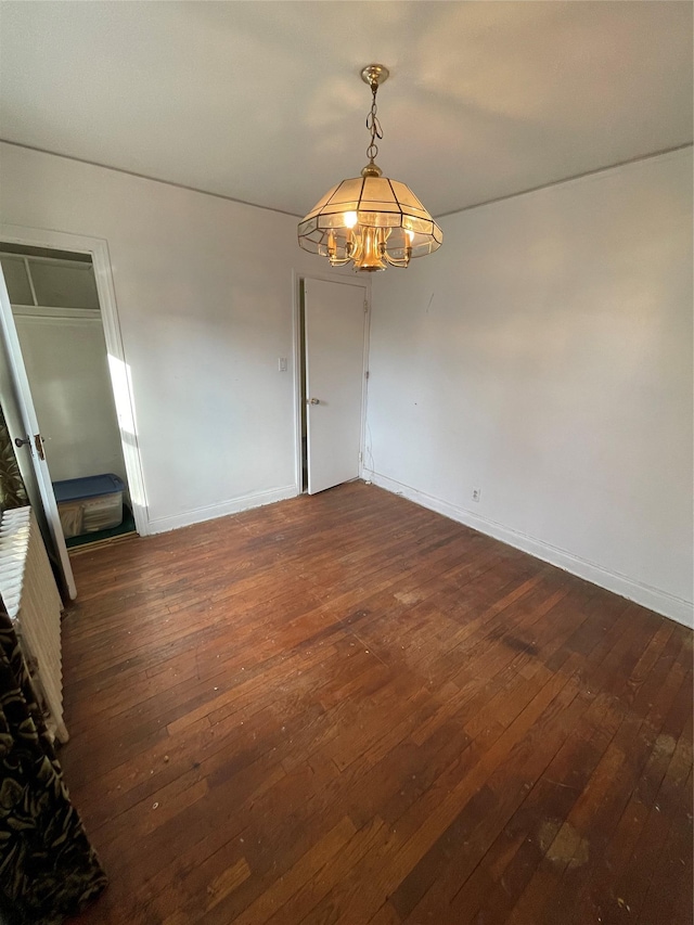 empty room with dark wood finished floors and baseboards