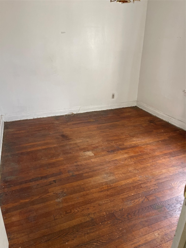 unfurnished room featuring dark wood-style floors and baseboards