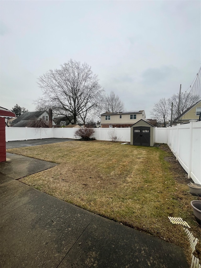 view of yard featuring a shed, a fenced backyard, and an outdoor structure