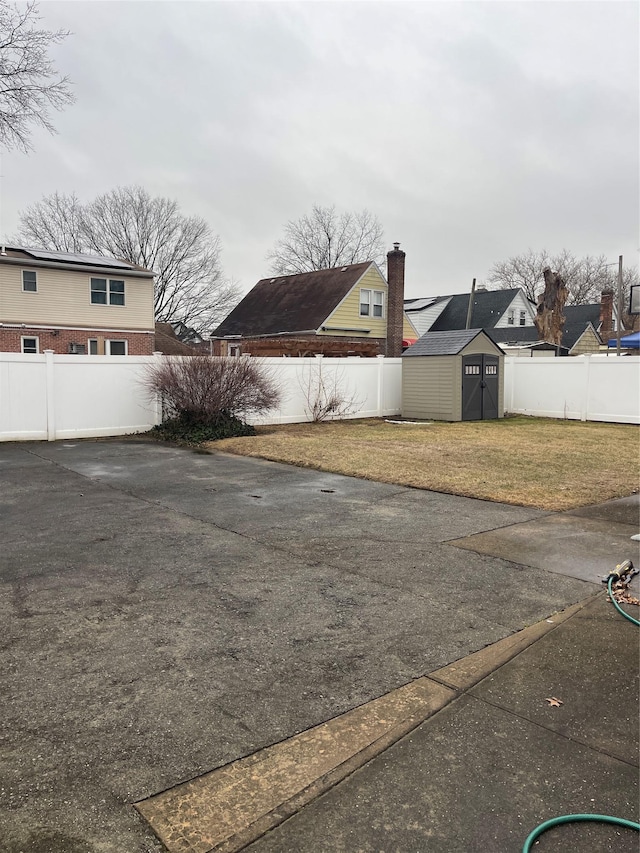 exterior space featuring a fenced backyard, a shed, and an outbuilding