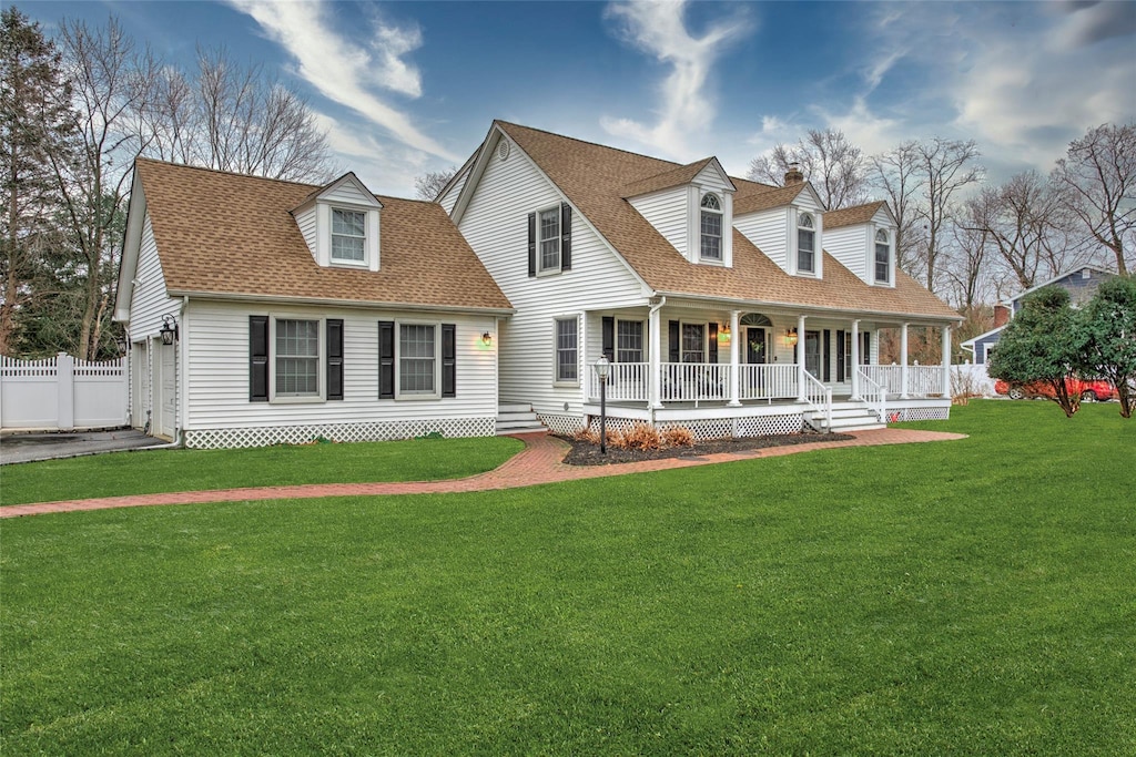 new england style home with a porch and a front lawn