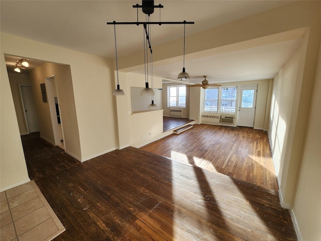 unfurnished living room featuring radiator and dark hardwood / wood-style floors