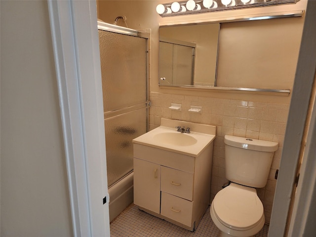 bathroom featuring vanity, tile walls, tile patterned floors, and toilet