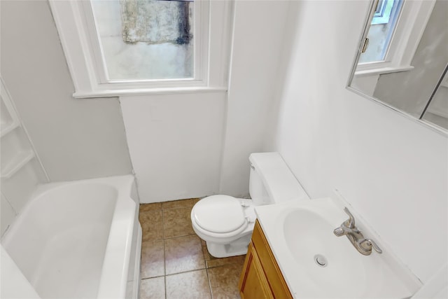 bathroom featuring a healthy amount of sunlight, vanity, toilet, and a washtub