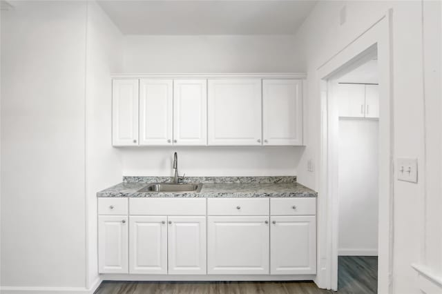 kitchen with dark hardwood / wood-style floors, sink, and white cabinets