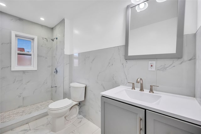 bathroom with vanity, toilet, and a tile shower