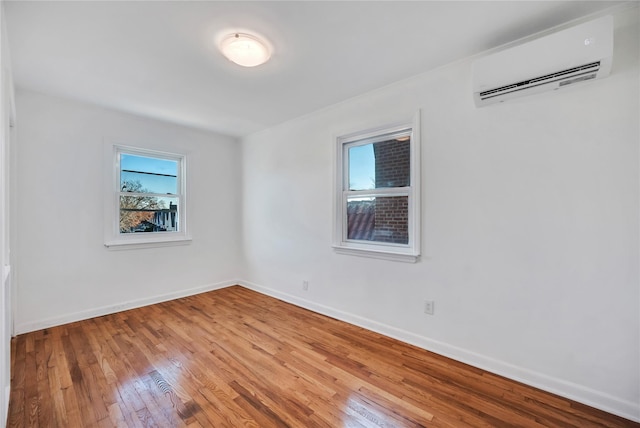 unfurnished room with wood-type flooring and a wall mounted AC