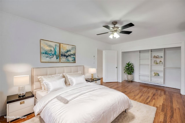 bedroom with hardwood / wood-style flooring, ceiling fan, and a closet