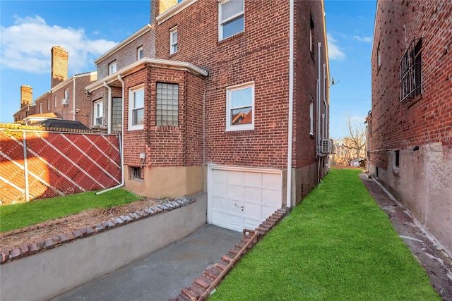 view of side of home featuring a garage and a lawn