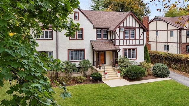 english style home featuring a front yard