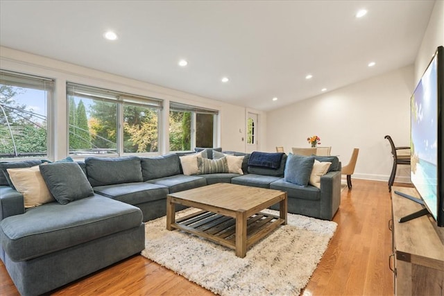 living room with vaulted ceiling and light wood-type flooring