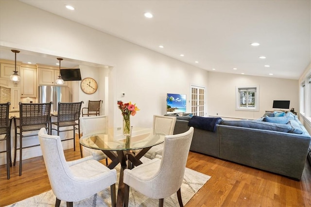 dining space featuring vaulted ceiling and light hardwood / wood-style floors