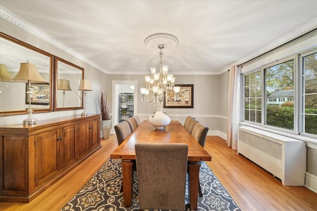 dining space featuring ornamental molding, a notable chandelier, radiator heating unit, and light hardwood / wood-style floors