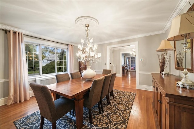 dining room featuring an inviting chandelier, crown molding, and light hardwood / wood-style floors