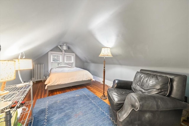 bedroom with lofted ceiling, dark hardwood / wood-style floors, and radiator