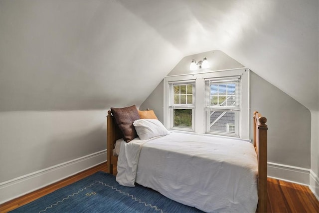 bedroom with dark hardwood / wood-style flooring and vaulted ceiling