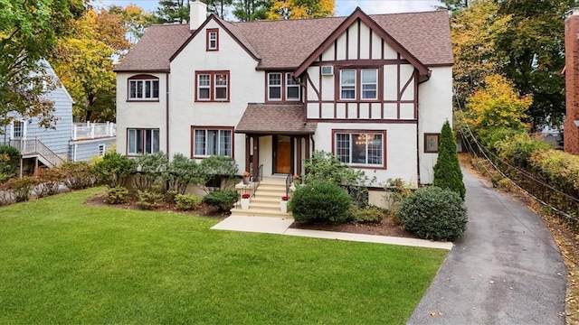 tudor-style house featuring a front yard