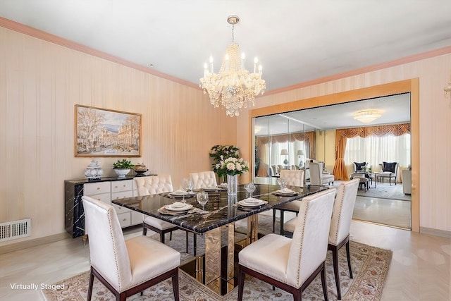 dining space with a notable chandelier and crown molding