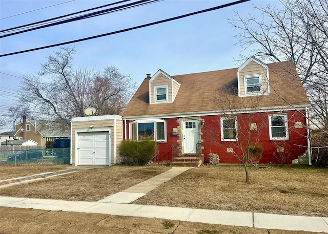 cape cod house with a garage and a front lawn