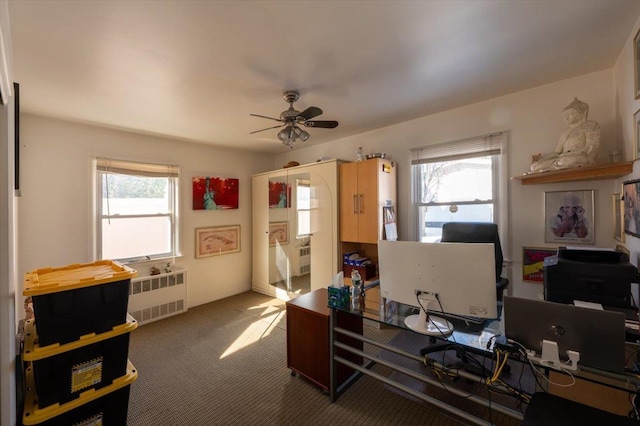 carpeted home office with radiator, a wealth of natural light, and ceiling fan