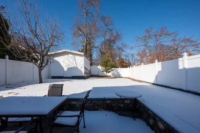 snow covered patio featuring a shed